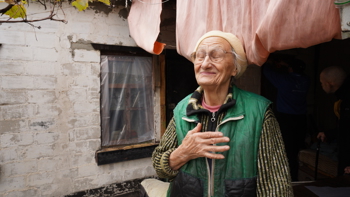 En kvinna står utanför sitt hem i Ukraina.