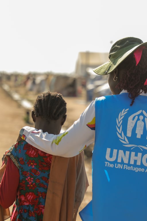 En UNHCR-medarbetare hjälper ett barn vid gränsen till Sudan.