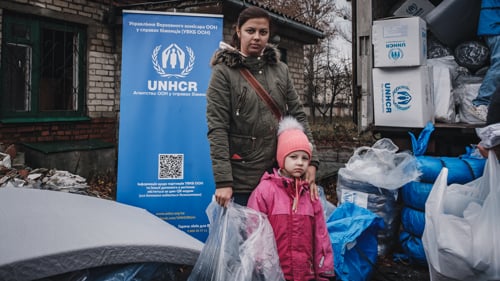 En mamma och barn får nödhjälp av UNHCR i Ukraina.