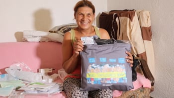 En kvinna som tidigare varit statslös visar upp sitt nya ID-kort.