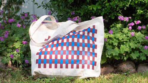 En tygkasse med rutigt mönster som är välkomstgåva för nya månadsgivare.