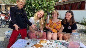 Fyra glada barn säljer kakor.