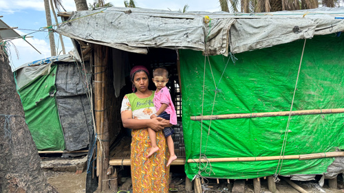 Ma Phyu Ma, 37 år, är rohingya och på flykt i sitt eget land. Här står hon framför sin tillfälliga bostad i delstaten Rakhine, som drabbades hårt när cyklonen Mocha slog till mot Myanmar 2023.