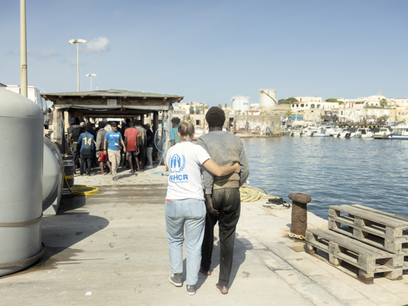 UNHCR-personal hjälper en flykting som kommit i land på Lampedusa.