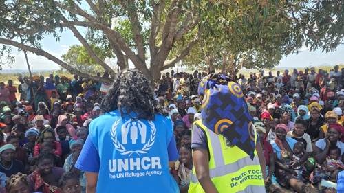 UNHCR-personal framför en folkmassa i Mocambique.