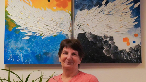 En kvinna på flykt från Ukraina står framför en tavla i Estland.