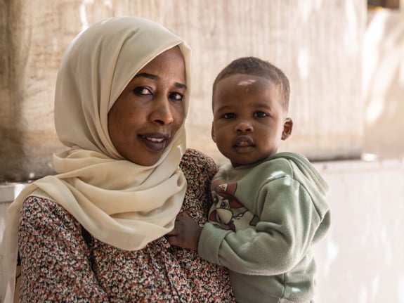 En mamma och hennes son på flykt i Sudan.