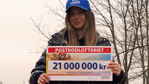 Maria Sur håller en check från Postkodlotteriet.