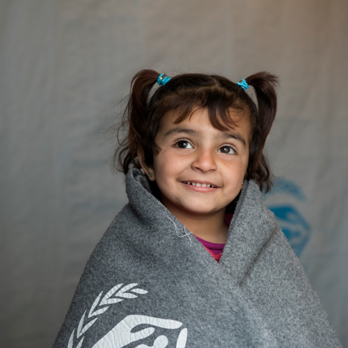 Amira är på flykt från Syrien. Hon har fått en tjock filt som hjälper under kyliga nätter i tält. Vill du värma en familj?