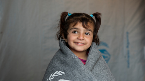 Amira är på flykt från Syrien. Hon har fått en tjock filt som hjälper under kyliga nätter i tält. Vill du värma en familj?