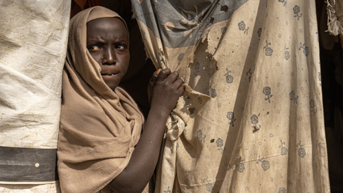 10-åriga Maha tittar ut från sitt boende i ett flyktingläger i nordvästra Etiopien. Hon, hennes syskon, mamma och mormmor har flytt undan våldet i Sudan. Foto: UNHCR/Tiksa Negeri