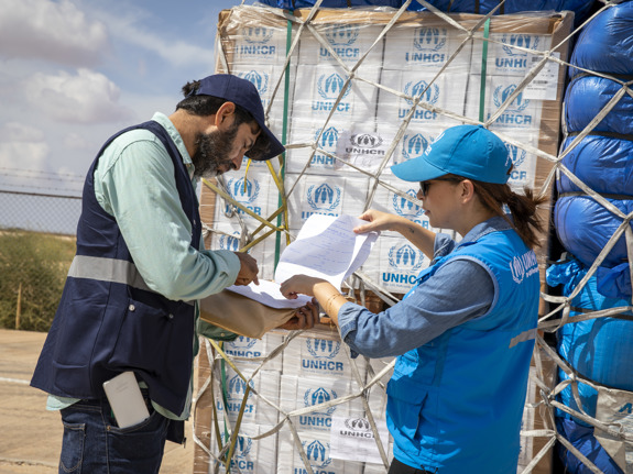 UNHCR-personal checkar av en lista från en försändelse med nödhjälp.