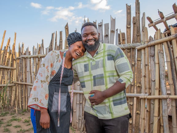 En man och en kvinna håller om varandra och skrattar. De är flyktingar från Demokratiska republiken Kongo.