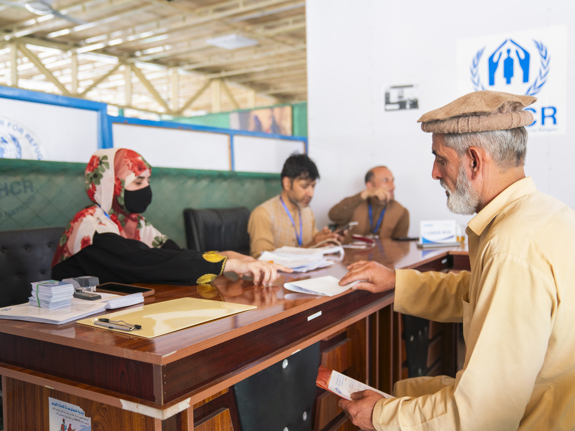 Bild från ett mottagningcenter i Afghanistan, där en man tar emot hjälp från administrationen.