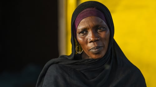 En kvinna från Sudan i sjal. Hon tittar mot kameran och ser allvarsam ut.