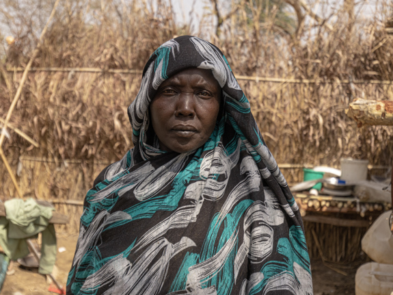 40-åriga Maha står bredvid sitt boende i ett flyktingläger i nordvästra Etiopien. Hon, hennes barn och mamma har flytt undan våldet i Sudan. Foto: UNHCR/Tiksa Negeri