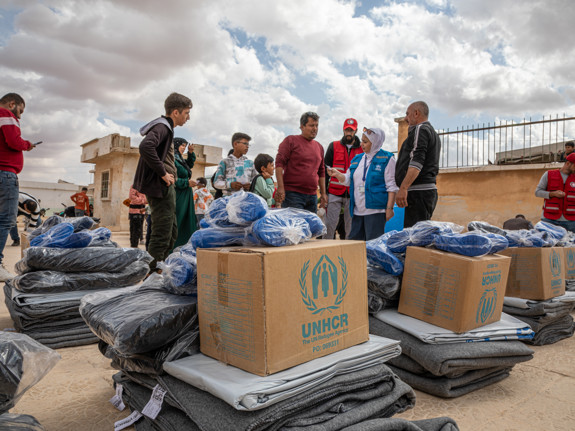 UNHCR-medarbetare delar ut paket med vinterhjälp.