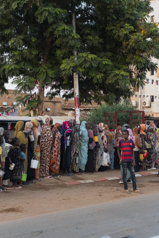 Människor som flytt kriget står i en kö för att få matutdelning.