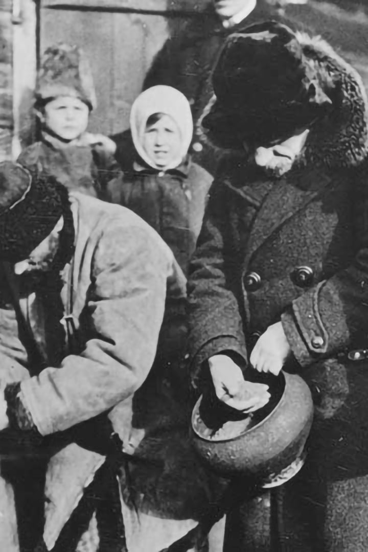 En svartvit bild från Ryssland på 1920-talet när Nansen undersöker en brödkö.