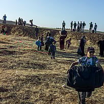 En pojke bär en väska när han flyr från Syrien.