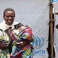 En kvinna håller två spädbarn i sina armar.