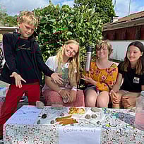 Fyra glada barn säljer kakor.