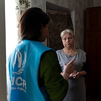 En ukrainsk kvinna pratar med UNHCR-personal