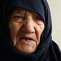 En kvinna i svart sjal.