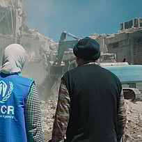 Två personer tittar på skadade hus efter jordbävningen i Turkiet och Syrien.