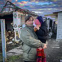 En kvinna håller sitt barn i famnen.