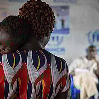 En kvinna håller ett sovande barn.