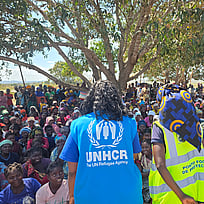 Hjälparbetare från UNHCR pratar med en folkmassa i Mocambique.