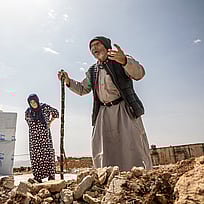 En äldre man och kvinna står utanför ett tält i Syrien.