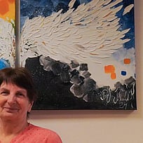 En kvinna på flykt från Ukraina står framför en tavla i Estland.