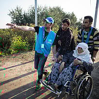 Människor på flykt får vägledning av UNHCR på väg mot en säker plats.