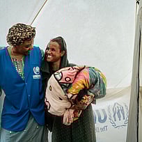 UNHCR:s fältarbetare håller om en kvinna på flykt.