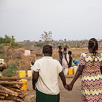 Två personer går hand i hand i riktning bort från kameran.