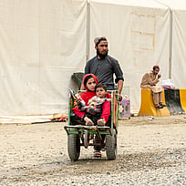 En utmattad afgansk familjer som återvänder från Pakistan vi gränsövergången Torkham – möter växande svårigheter.
