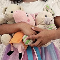 En flickas kropp syns med gosedjur.