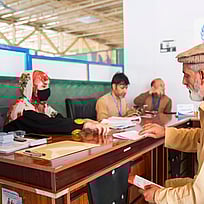 Bild från ett mottagningcenter i Afghanistan, där en man tar emot hjälp från administrationen.