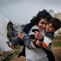 Två bröder leker och kramas i ett flyktingläger i Libanon.