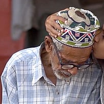 En morfar får en puss av sitt barnbarn.