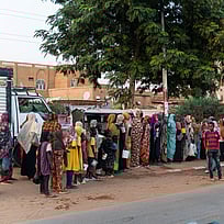 Människor som flytt kriget står i en kö för att få matutdelning.