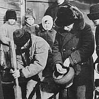 En svartvit bild från Ryssland på 1920-talet när Nansen undersöker en brödkö.