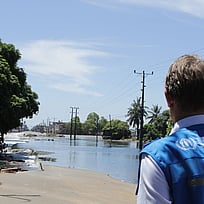 En hjälparbetare blickar ut över en översvämmad gata.