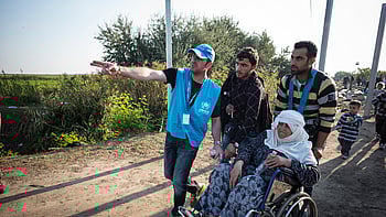 Människor på flykt får vägledning av UNHCR på väg mot en säker plats.