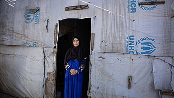 Den syriska flyktingen Shadia Mohammad Jesm, 50 år, står vid dörren till sitt tält i flyktinglägret Jasmine i Saadnayel, Libanon, där hon har bott de senaste fem åren. "Det är väldigt osäkert i Syrien just nu", säger Shadia. "Vi vill återvända, men vi är rädda. Jag önskar bara det bästa för mitt land." Foto: UNHCR/Ximena Borrazas