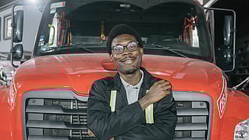 En man framför en röd bil.