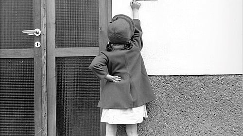 En svartvit bild på en ung flicka som ringer på dörren till UNHCR.