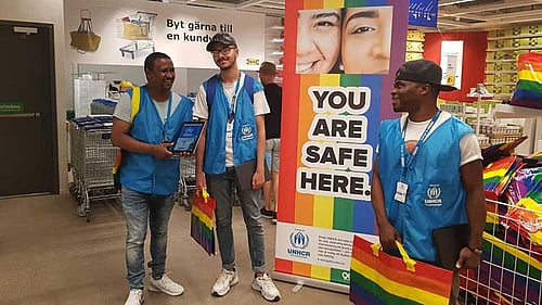 Foto från IKEA-varuhus. Tre män i UNHCR-väst rekryterar givare.